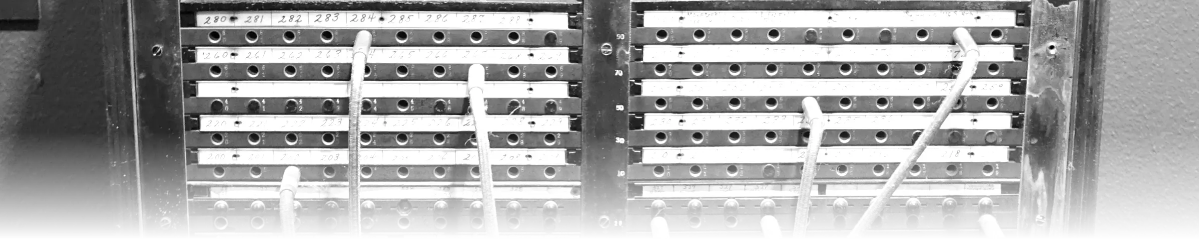 A c. 1949 Western Electric manual telephone switchboard, densely packed with numbered jack rows and patch cords routing individual connections by hand.