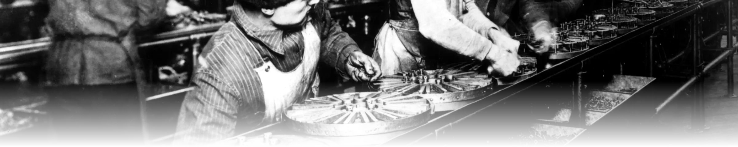 Workers assembling flywheel magnetos along the moving conveyor at Ford’s Highland Park plant in 1913, the year the first moving assembly line was introduced