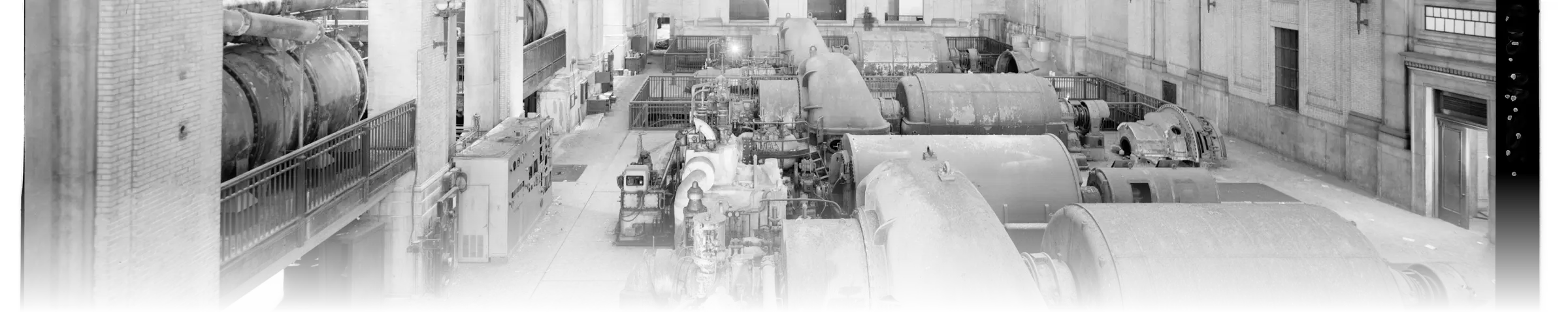 Historic turbine hall at a power station, showing a wide row of nominally identical turbine-generator units built and operated to the same specification