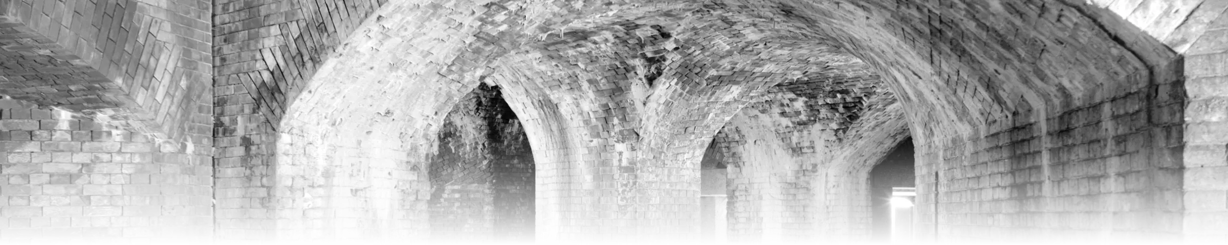 A row of brick barrel-vault arches receding into depth under a bastion at Fort Delaware, historic defensive masonry documented by the National Park Service