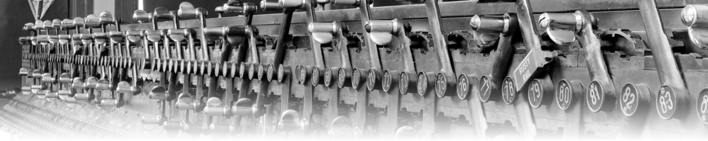 A row of numbered mechanical levers on a 1910s railway interlocking machine, each one routing traffic to a specific track