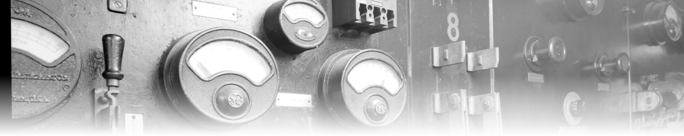 A black-and-white photograph of a shipboard electrical switchboard, dense with ammeters, voltmeters, breakers, and labelled buses